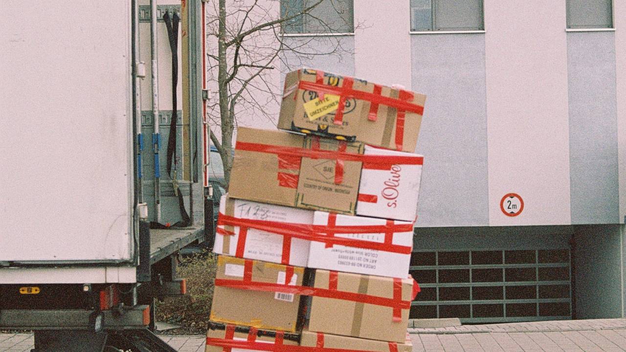 A stack of cardboard boxes next to a lorry